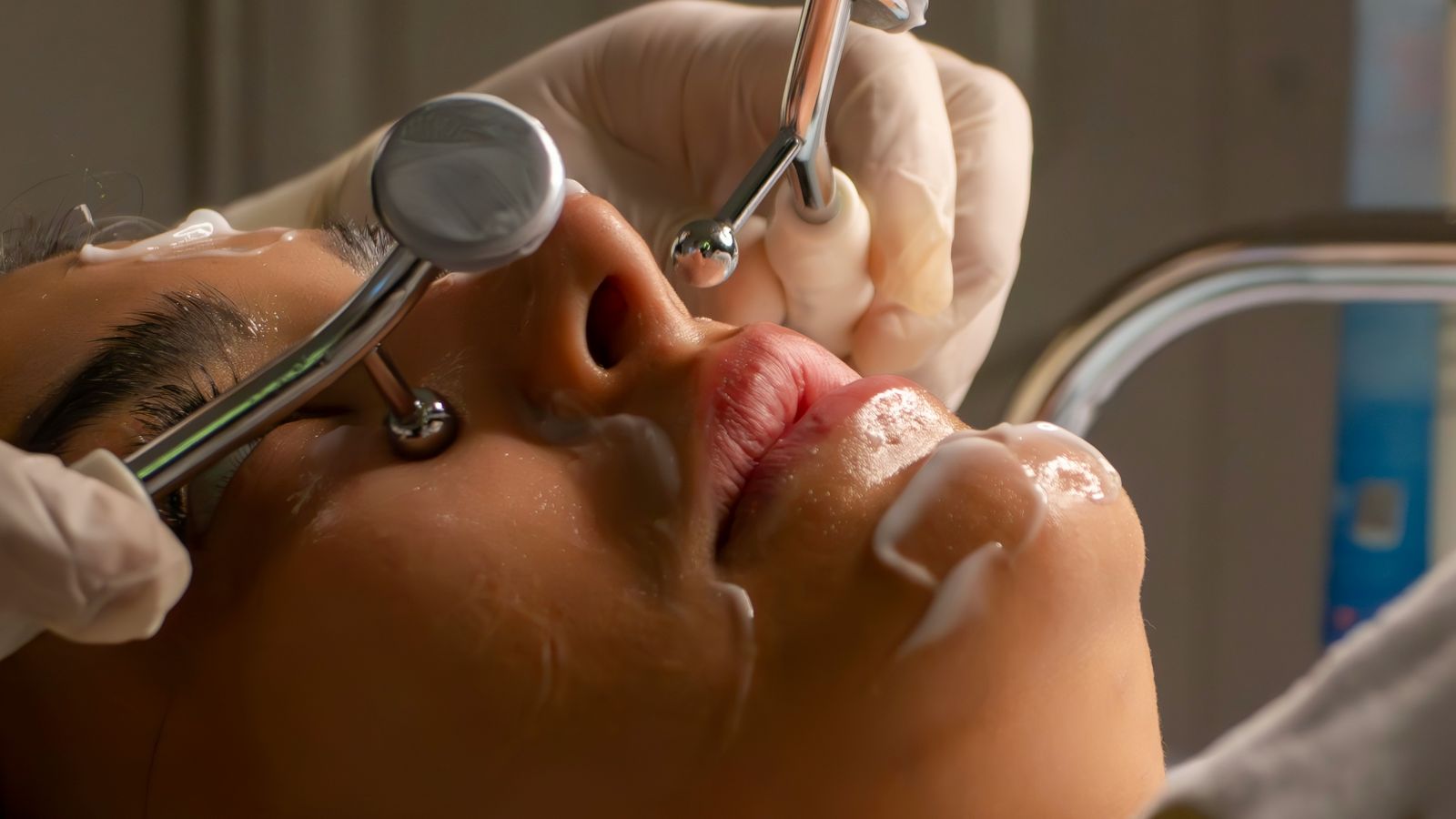 A practitioner carrying out a facial treatment in an aesthetic clinic