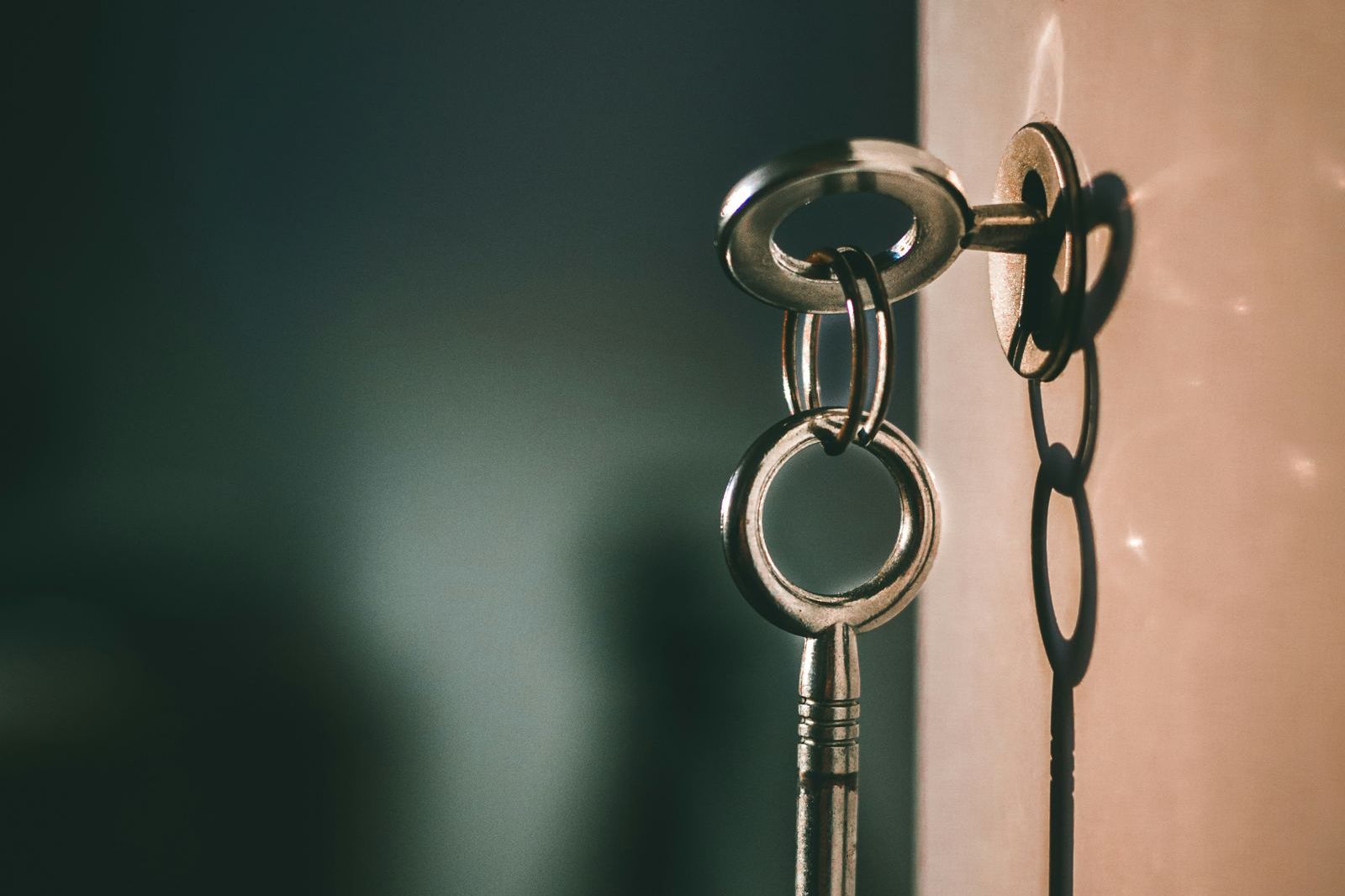 A set of keys hanging on a chain from a door
