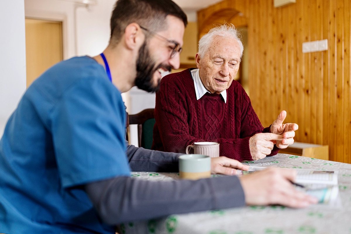 A care worker sitting with an older man